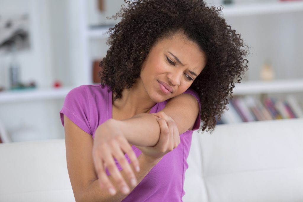 Woman holding painful elbow - AOA Orthopedic Specialists